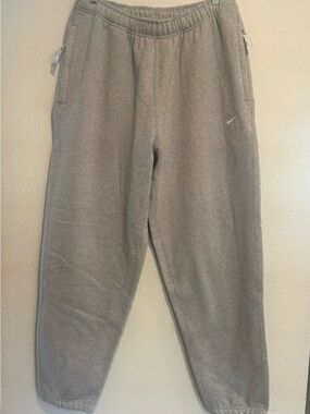 Nike Men’s Gray Fleece Joggers with White Swoosh and Zipper Pockets
